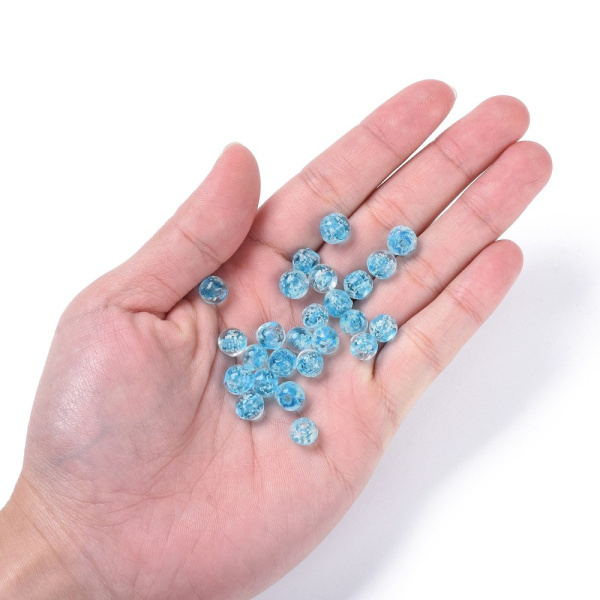 <p>Бусины ручной работы из прозрачного стекла с голубой сердцевиной и белыми крапинками внутри. В темноте бусины светятся зеленоватым светом. Выполнены в технике лэмпворк (лампворк, lampwork). Могут немного отличаться по форме и размеру. Бусины могут быть покрыты белым налетом - пылью из отверстия, которая легко стирается. Оттенок может отличаться от фотографии и в разных поставках. Цена за 10 бусин.</p>