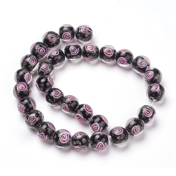 <p>Стеклянная бусина лэмпворк ручной работы. Бусина черного цвета со спиральным узором розового цвета и золотистыми блестками. Оттенок может отличаться от фотографии. Диаметр отверстий - около 1.2-1.6 мм. Бусины могут немного отличаться по форме и размеру. Цена за 2 шт.</p>
