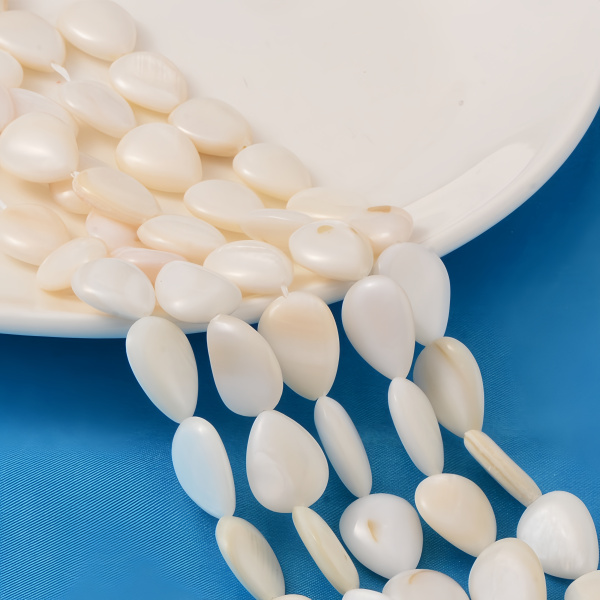 <p>Кремово-белые бусины из натурального перламутра в форме плоских капелек. Бусины могут немного отличаться по форме, размеру и цвету. Возможны щербинки и пятна естественного происхождения, отверстия сделаны не очень аккуратно. Оттенок может отличаться от фотографии и в разных поставках. Цена за низку длиной примерно 34 см, около 21 бусины. Низки формируются без проверки каждой бусины на дефекты.</p>