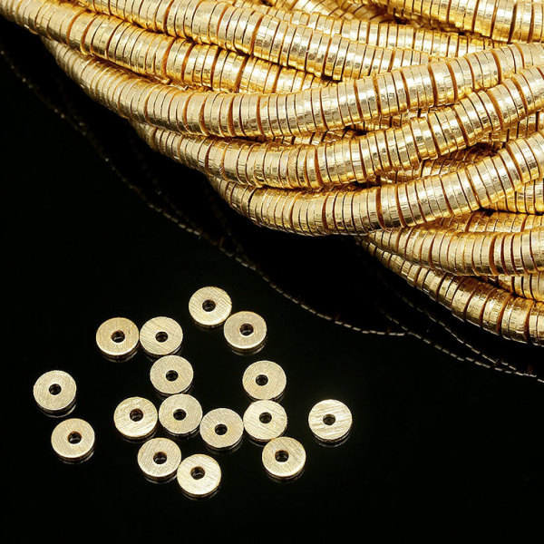 <p>
 Качественная корейская фурнитура класса люкс. Металлическая бусина - узкая рондель Heishi (диск, чипс) с шершавой поверхностью. Диаметр отверстия - около 0.8-0.9мм. Материал - латунь, покрытие - позолота 16 карат. Оттенок может отличаться от фотографии и в разных поставках. Бусины могут немного отличаться по форме и размеру, отверстие может быть не строго по центру. Цена за 10 шт.
</p>