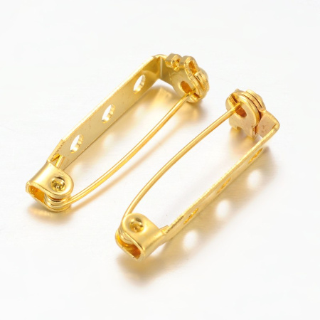 <p>Основа для броши с фиксирующимся замком. Имеется три отверстия диаметром около 2 мм. Декор можно приклеить или пришить. Цвет под золото. Оттенок может отличаться от фотографии и в разных поставках. Цена за упаковку 10 грамм (около 11-12 штук). Броши расфасованы без проверки на дефекты.</p>