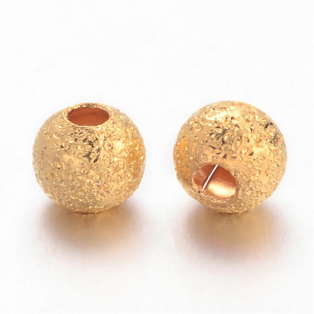 <p>Металлическая бусина с покрытием звездная пыль (stardust) золотистого цвета. Оттенок может отличаться от фотографии. Основной материал из которого изготовлена бусина - латунь. Диаметр отверстия около 1 мм. Цена за 5 грамм (около 54 бусин).</p>