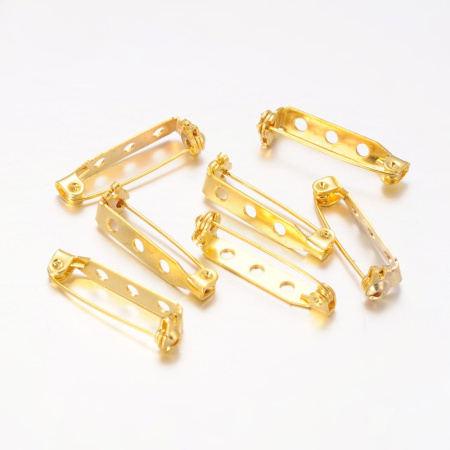 <p>Основа для броши с фиксирующимся замком. Имеется три отверстия диаметром около 2 мм. Декор можно приклеить или пришить. Цвет под золото. Оттенок может отличаться от фотографии и в разных поставках. Цена за упаковку 10 грамм (около 11-12 штук). Броши расфасованы без проверки на дефекты.</p>