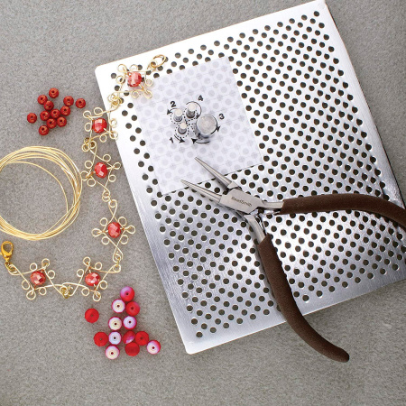 <p>
Металлический набор для работы с проволокой Wig A Ma Jig Deluxe (аналог WigJig и Thing A Ma Jig Deluxe). Изготовлен из закаленного алюминия, очень прочный и надежный. В комплекте 1 алюминиевая доска, 30 металлических колышков - насадок (20 малых, 6 средних, 2 больших и 2 очень больших), силиконовые закрепители для колышков. В комплект также входит подробная инструкция с примерами (на английском языке + картинки). Рабочая площадь поверхности составляет около 140*114 мм. Допустимо смещение 1-2 отверстий (могут быть просверлены не равномерно). По почте отправляется только по предоплате. Инструмент произведен американской компанией Bead Smith в Китае.
</p>
<p>
О работе с этим инструментом читайте в нашей статье <a href="https://stilnaya.com/blog/1-stati/80-instrument-dlya-raboty-s-provolokoj.html" title="Как использовать инструменты для работы с проволокой" target="_blank">«Как использовать инструменты для работы с проволокой»</a>
</p>