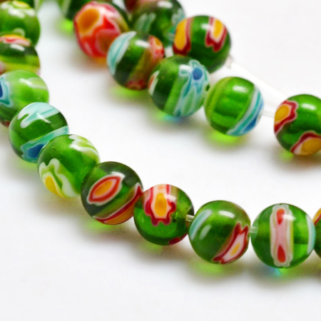 <p>Стеклянные бусины ручной работы, выполнены в технике миллефиори. Зелёные бусинки с разноцветными узорами. Оттенок может отличаться от фотографии и в разных поставках. Цена за низку около 65 бусин (низки формируются без проверки каждой бусины на дефекты).</p>