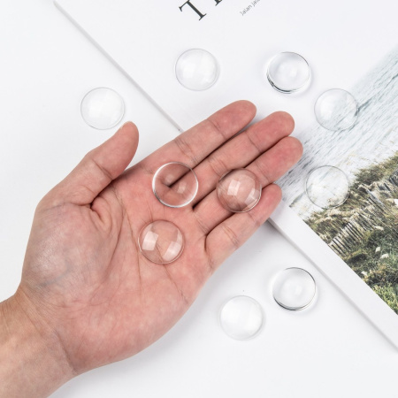 <p>
 Круглый стеклянный прозрачный кабошон, толщина 5-8 мм. Диаметр примерно 24,7 мм. Хорошо смотрится в рамке с подложенной под него картинкой или фотографией. На кабошонах возможны небольшие царапинки. Цена за упаковку 40-50 грамм в зависимости от толщины кабошонов (около 10 штук, фасуются без проверки на дефекты).
</p>