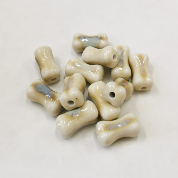 <p>Фарфоровая (порцелановая) бусина - кость ручной работы. Цвет - бежевый с голубовато-серым. Отверстие примерно 2 мм. Оттенок может отличаться от фотографии и в разных поставках. Цена за 5 бусин.</p>