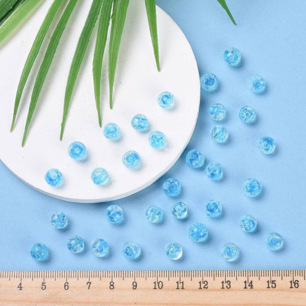 <p>Бусины ручной работы из прозрачного стекла с голубой сердцевиной и белыми крапинками внутри. В темноте бусины светятся зеленоватым светом. Выполнены в технике лэмпворк (лампворк, lampwork). Могут немного отличаться по форме и размеру. Бусины могут быть покрыты белым налетом - пылью из отверстия, которая легко стирается. Оттенок может отличаться от фотографии и в разных поставках. Цена за 10 бусин.</p>